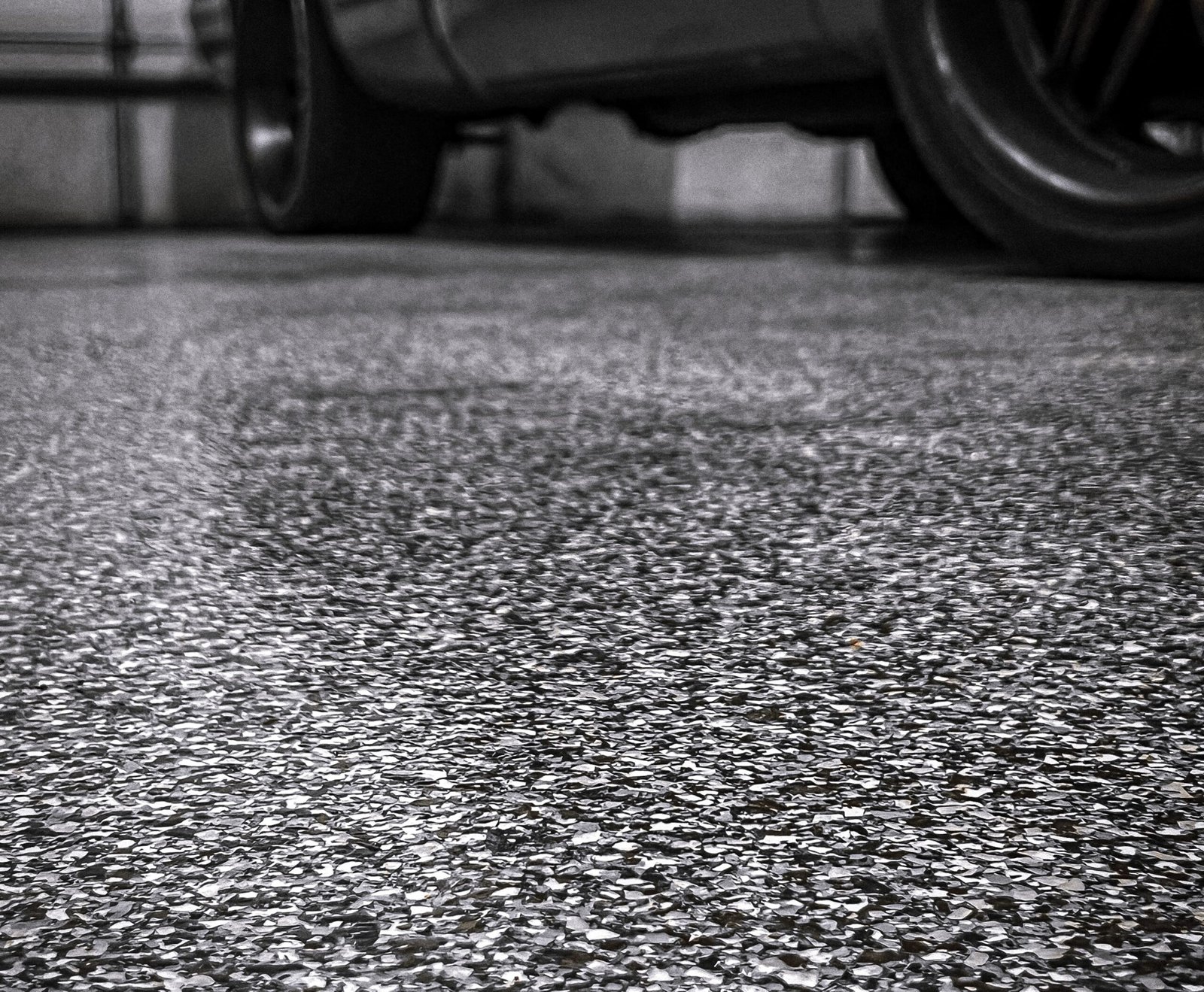 Professional contractor applying floor coating in garage